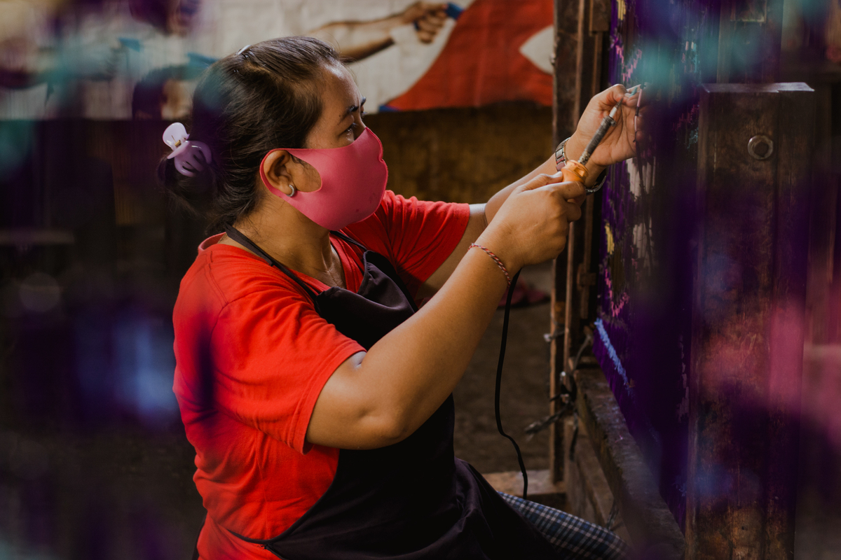 a lady spraying dye onto the clothing